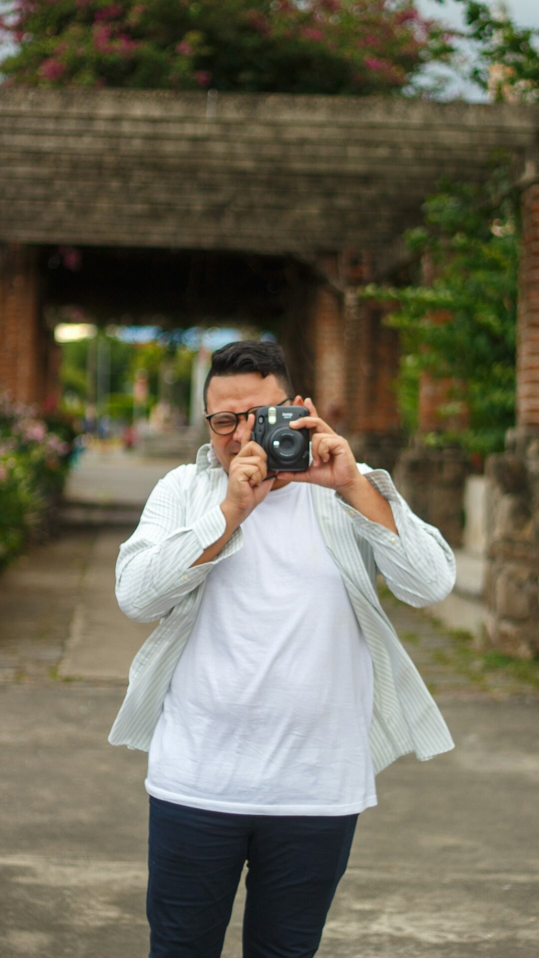 Latino man holding a camera outdoors