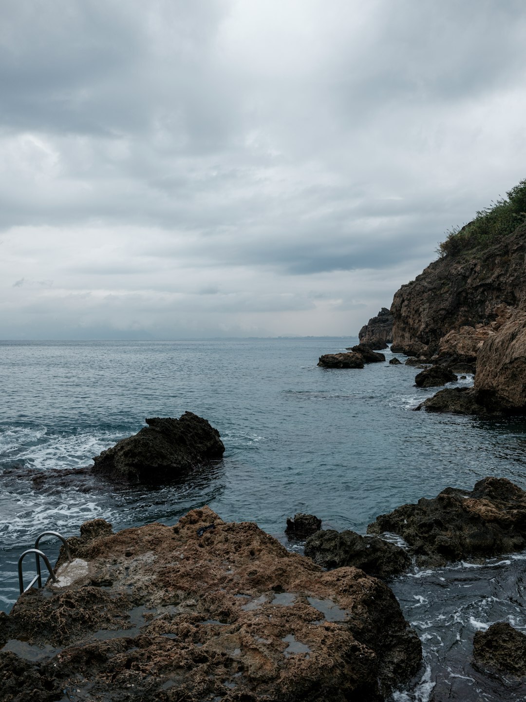 Rocky coastline with waves under an overcast sky